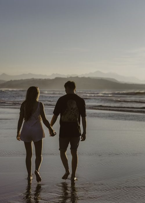 Happy couple in Byron Bay Couple holding hands on Byron Bay Beach
