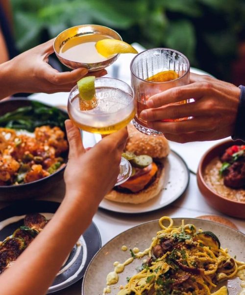 No-Bones-Glasses-Clink Three people clinking different cocktails at dinner