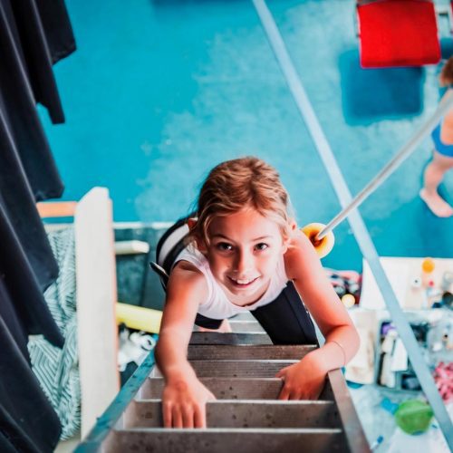 circus-arts-australia-byron-bay-flying-trapeze-classes-indoor-kids-adults-fun-fitness-activities-safety-harness Kid enjoying climbing at Circus Arts Byron Bay