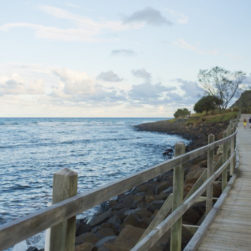 Sunset Beachside Exercise "Lennox Head, NSW, Australia - January 29, 2013: Early evening exercisers walk on the boardwalk by the beach at Lennox Head"